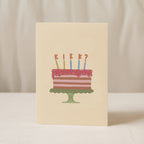Funny birthday greeting card featuring an illustrated cake with candles and the word "KIEK?" instead of candle flames, humorous minimalist birthday design.