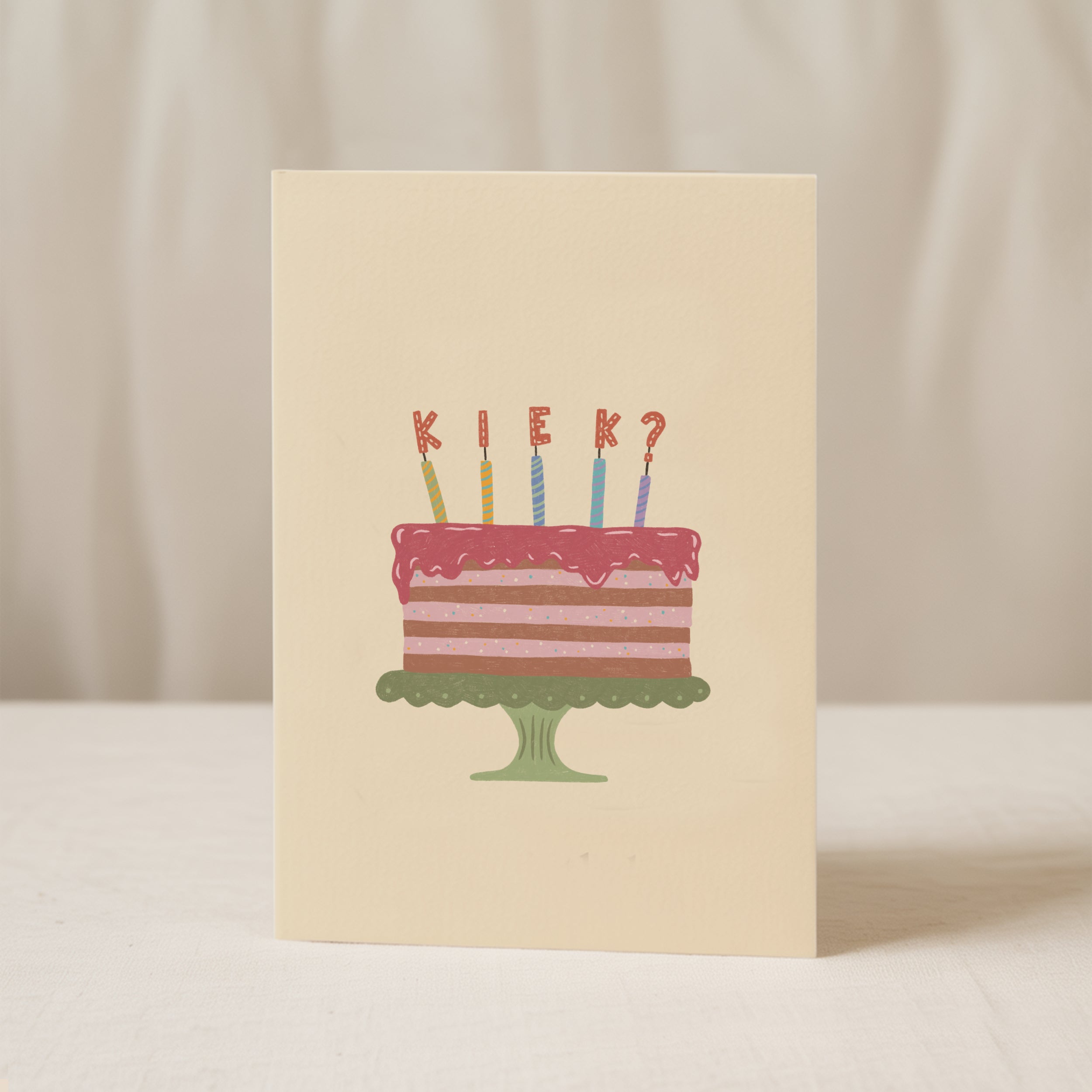Funny birthday greeting card featuring an illustrated cake with candles and the word "KIEK?" instead of candle flames, humorous minimalist birthday design.