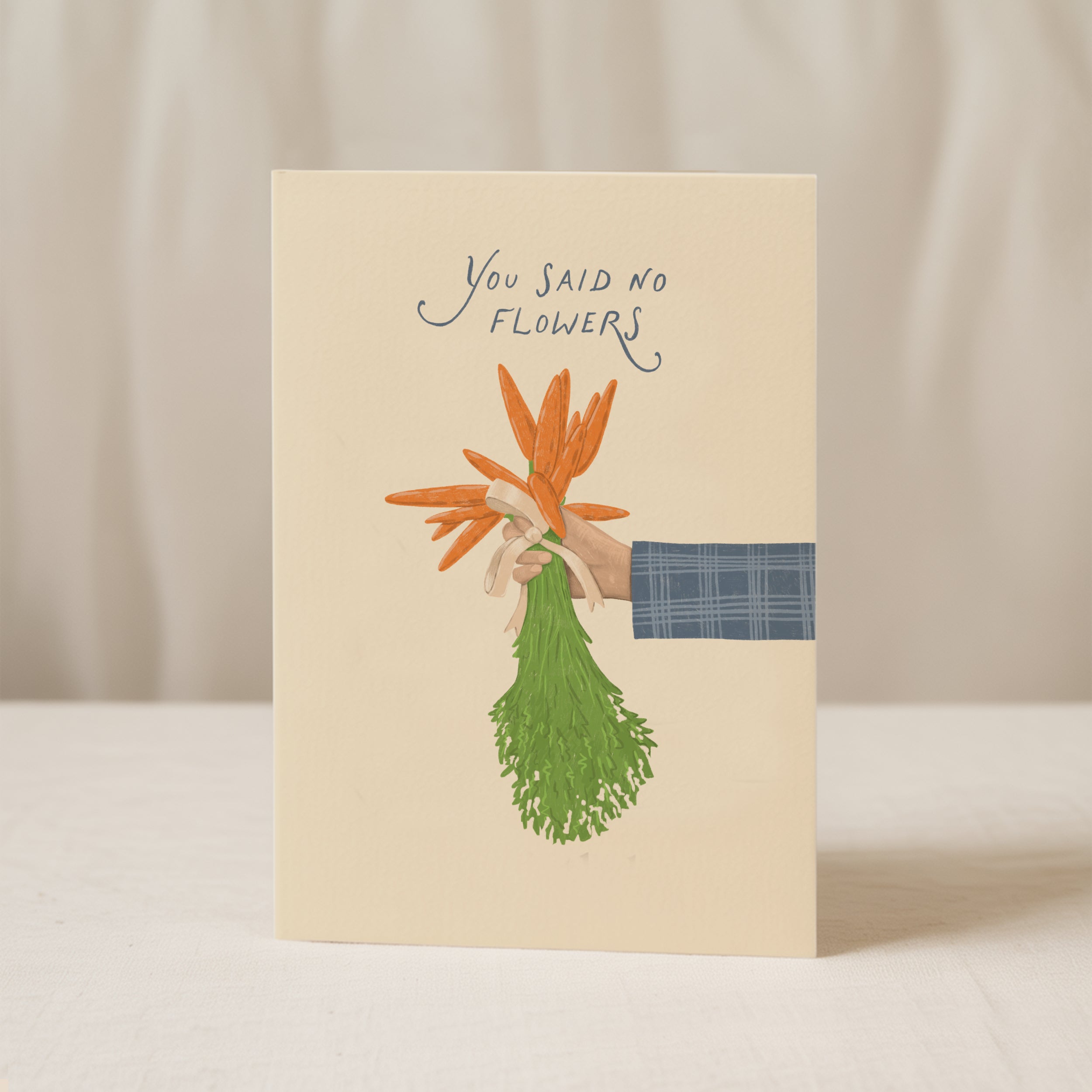 Funny wedding greeting card showing a hand holding a bouquet of carrots instead of flowers with the text “You said no flowers”, humorous minimalist wedding design.