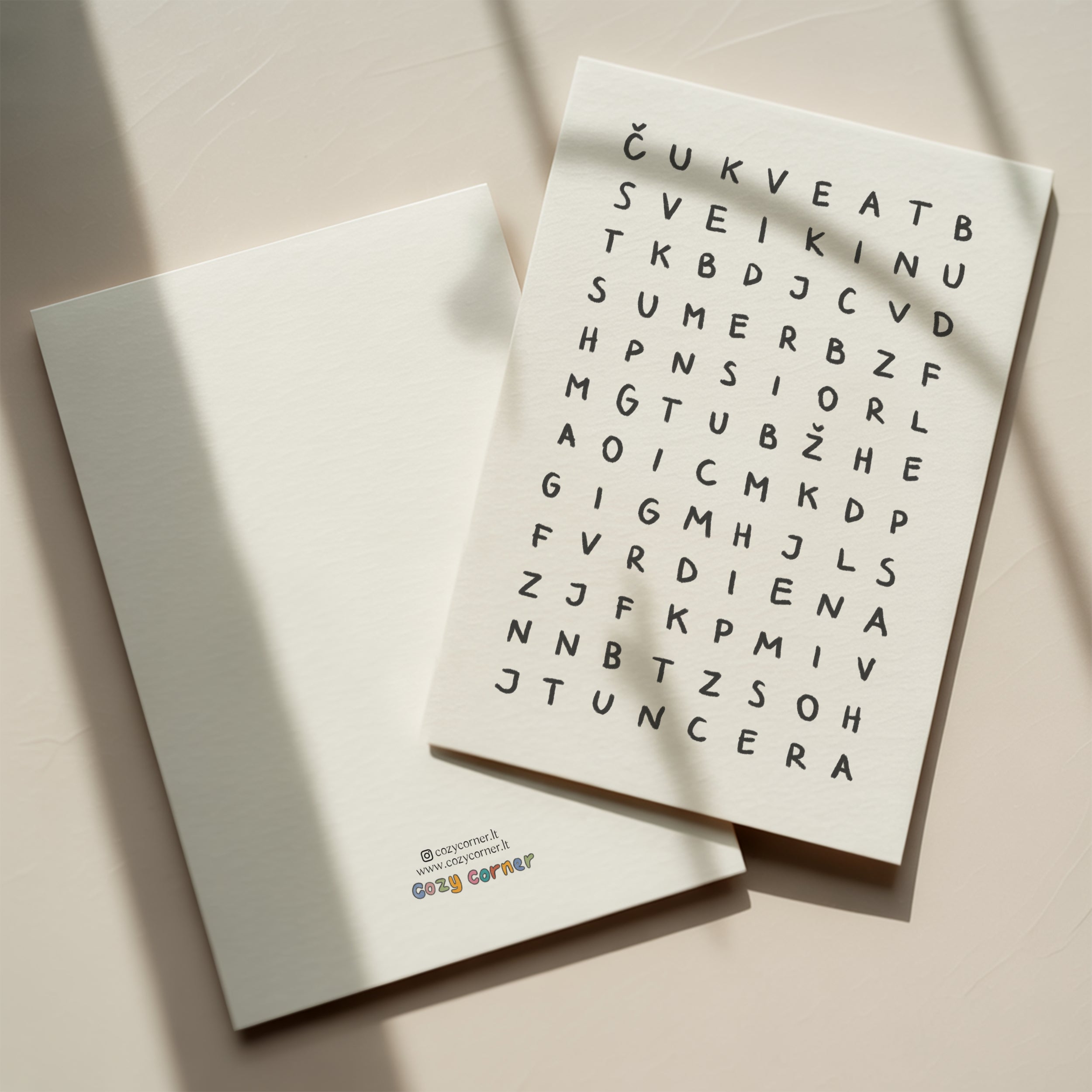 Minimalist birthday greeting card featuring a crossword-style letter puzzle with the hidden message “Sveikinu su gimimo diena” on a white background.