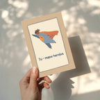 Cute greeting card featuring a teddy bear flying like a superhero with the text “Tu – mano herojus” below, whimsical hero-themed illustration.
