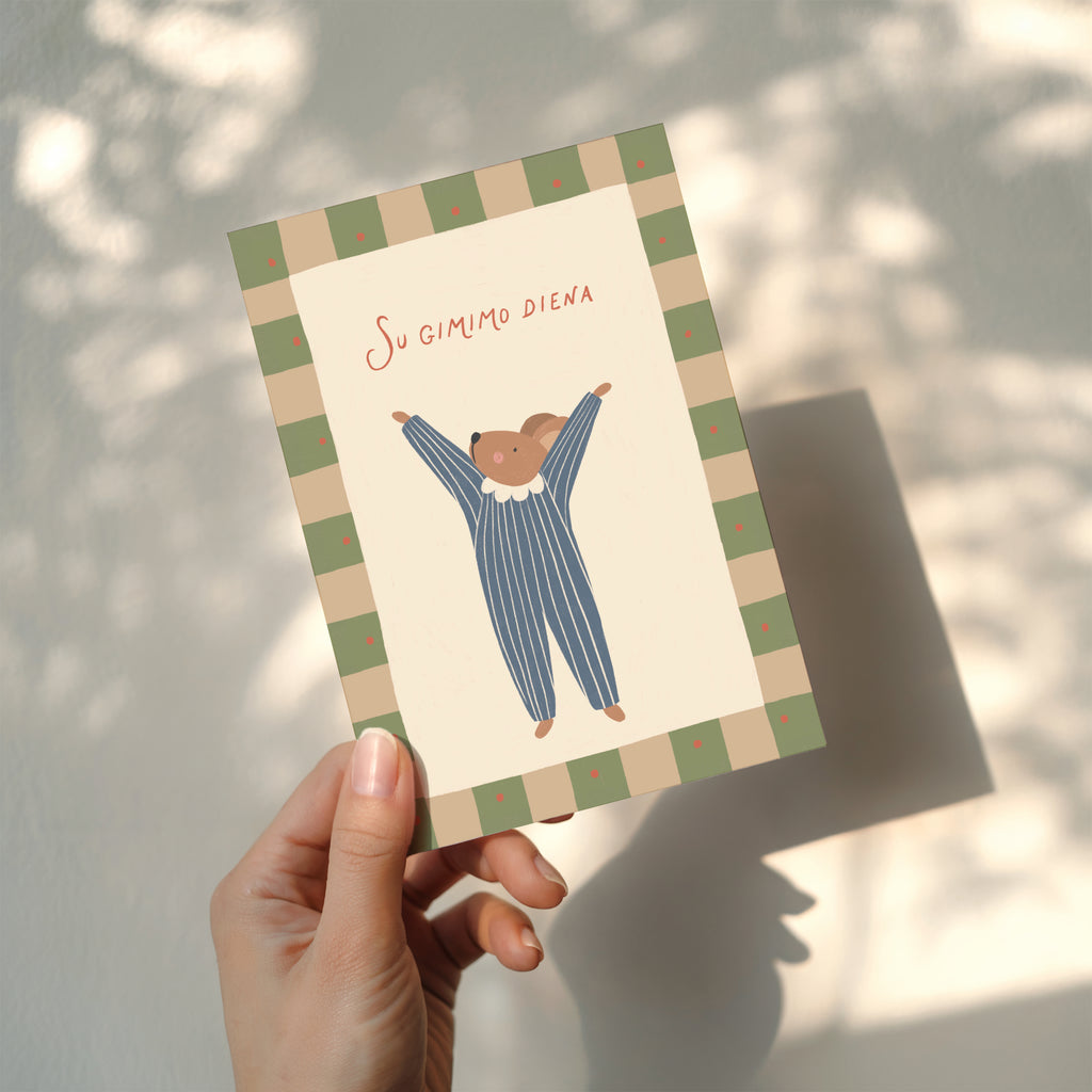 Birthday greeting card featuring a cute mouse with raised arms holding a “Su gimimo diena” sign, whimsical and cheerful birthday card design.