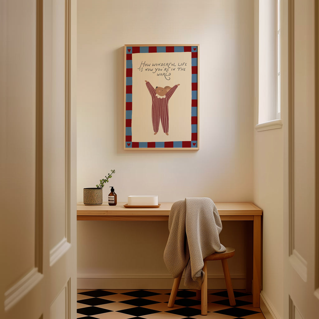 Cute storybook mouse wearing a striped outfit, standing with arms raised and pointing toward the quote "How wonderful life is now you're in the world". Beige background with a blue and burgundy gingham-style border, printable nursery wall art.