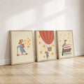 Storybook mouse wall art set featuring a mouse on a scooter, a mouse sitting on books, and a mouse in a hot air balloon with starry details